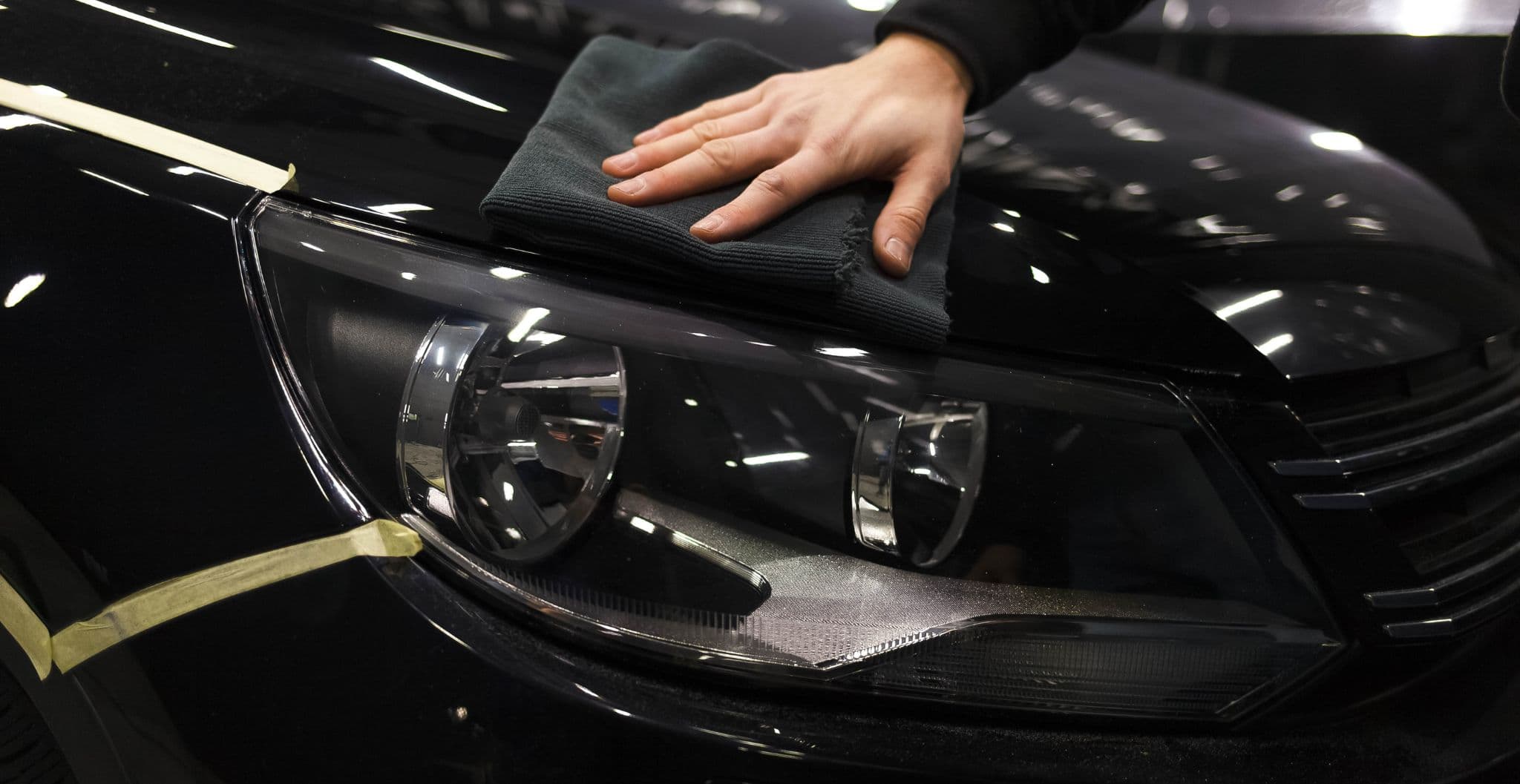 Buffing a ceramic-coated black car to a deep gloss finish in Vancouver
