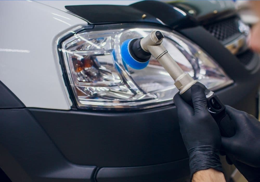 Technician machine-polishing a foggy headlight during restoration in Vancouver